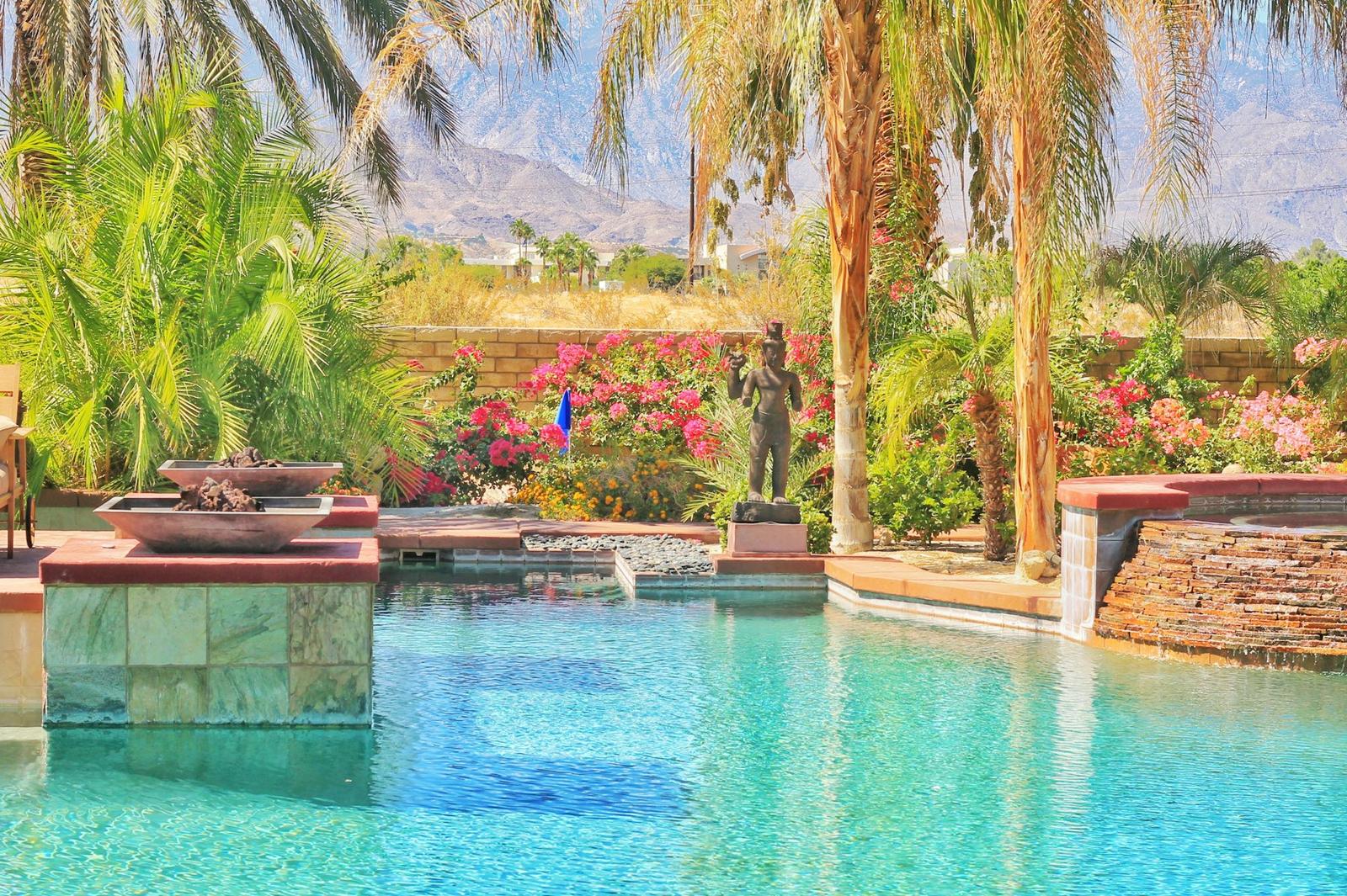 A stone-edged pool with palms and bougainvillea